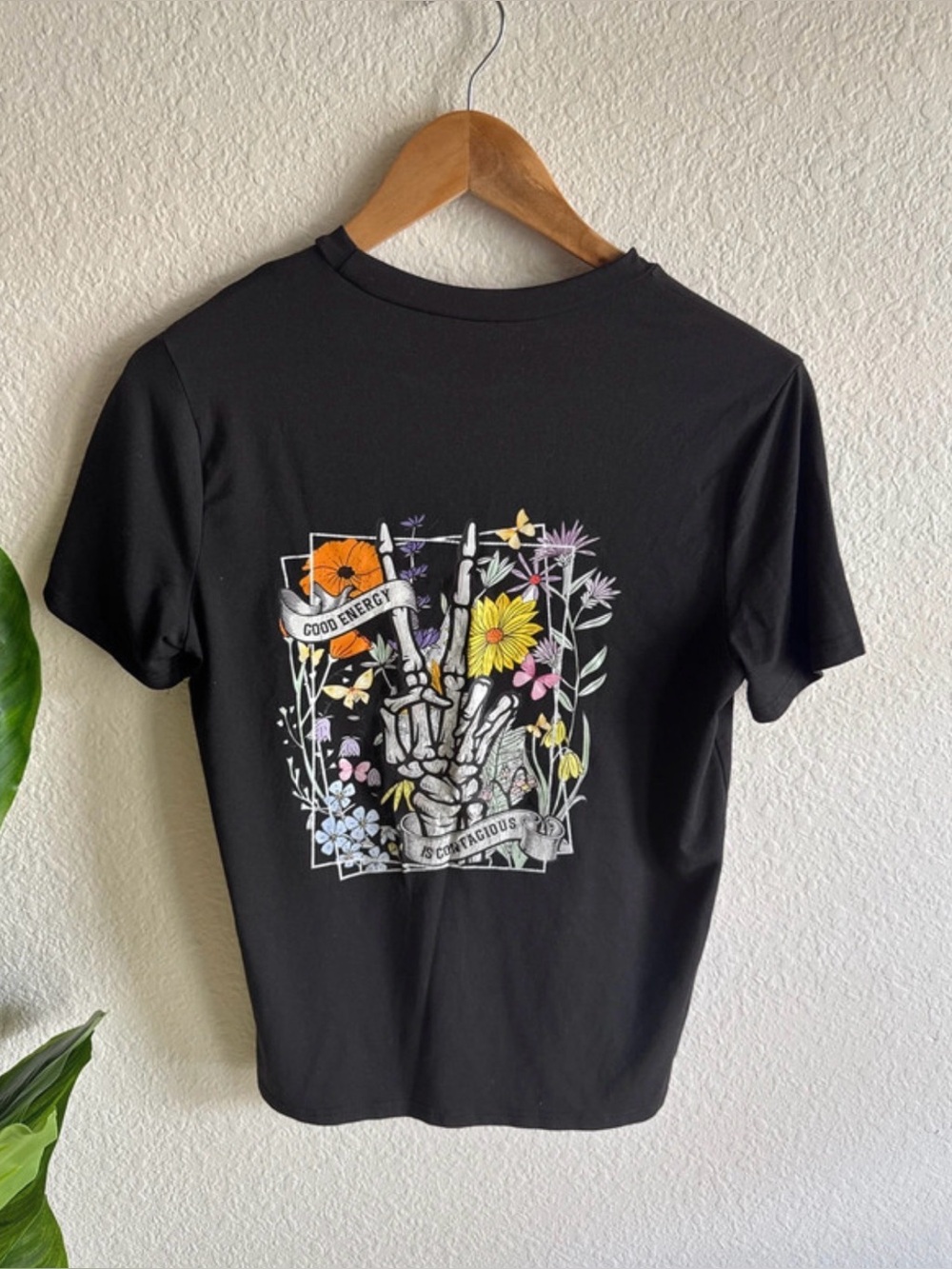 Black Graphic Tee with Floral and Skeleton Design ‘Good Energy is Contagious’